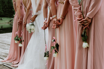 Bride and bridesmaid holding roses during the wedding ceremony