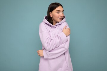 Obraz premium Shot of attractive happy smiling young woman wearing casual outfit standing isolated over colourful background with empty space looking to the side
