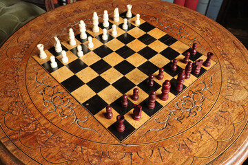 An old chess set on a purpose build carved chess board and table in an English country house