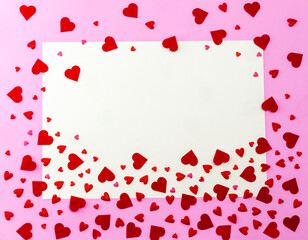 Confetti hearts on pink background with postcard and copy space. Red decorative heart. There was plenty of room for text in the apartment. The concept of Valentine's day