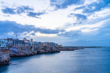 Fototapeta na wymiar Sunset by the sea in Polignano a Mare in Puglia, Italy
