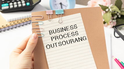 BUSINESS PROCESS OUTSOURANG text on paper in hand.