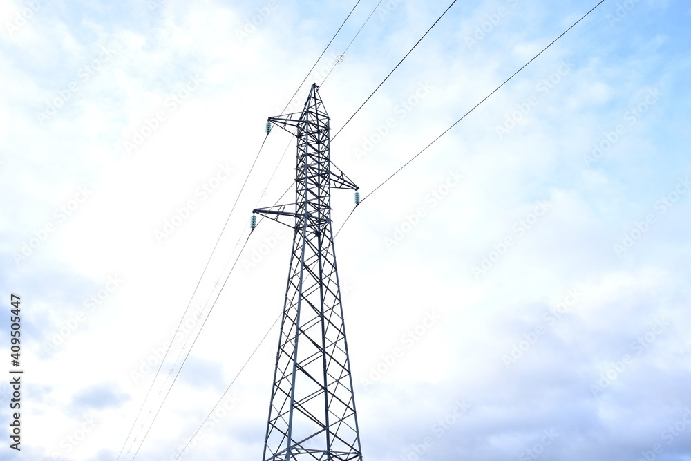 Wall mural Medium voltage electricity tower on the mountain. Blue sky background with clouds.