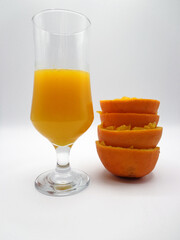 Orange juice accompanied with interleaved and fencing oranges, isolated on a white background