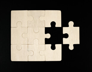 Fototapeta premium Putting last jigsaw puzzle piece. Solving and completing the task. The correct solution. Assembling white jigsaw puzzle pieces.