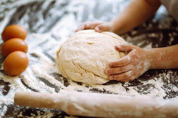 Children hands kneading dough on wooden table. Easter baking preparation. Cookies for Christmas. 