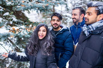 group of four indian having fun playing in snow outdoors spending Chrisymas holidays