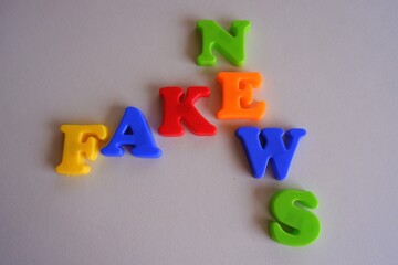 Fake news words in colorful plastic magnetic letters on a light background