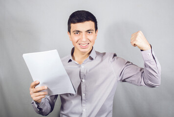 man looks at papers and rejoices