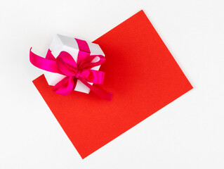 Gift in a white box with red baht and red paper sheet on a white background
