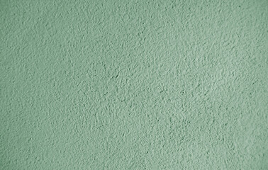 Abstract grainy texture on light green wall. It can be used as a design element and background