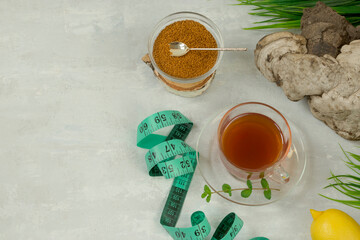 Chaga birch mushroom is a trendy superfood for diet and immunity. Natural tea, coffee and pieces of birch chaga in a glass cup, measuring tape on a light background. Natural antioxidant. Copy space.