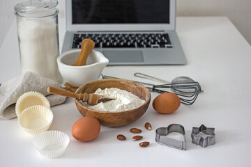  Ingredients for baking and a laptop on the table in the kitchen