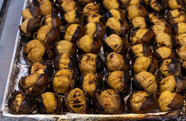 Full tray of huge roasted chestnuts close-up. Street snacks for tourists in Istanbul during all seasons.