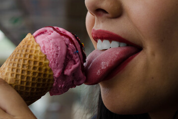 mouth of a girl eating a blackberry ice cream