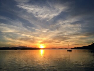 Fototapeta na wymiar Sundown over a beautiful bay with a sailboat anchored out in the Gulf Islands, British Columbia, Canada