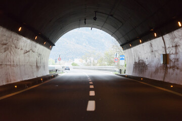 Drive through an empty highway tunnel before exciting the light
