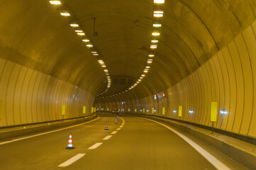 Drive through an empty highway tunnel before exciting the light