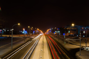 Fototapeta na wymiar Winter night road in city, snow background