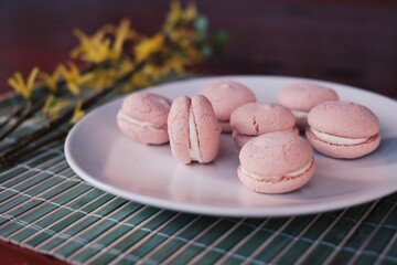 macaroons on a wooden table, spring is coming, yellow flowers