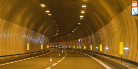 Drive through an empty highway tunnel before exciting the light