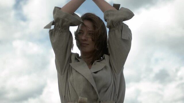 Young woman modelling and looking into camera with wind in her hair. Slow motion.