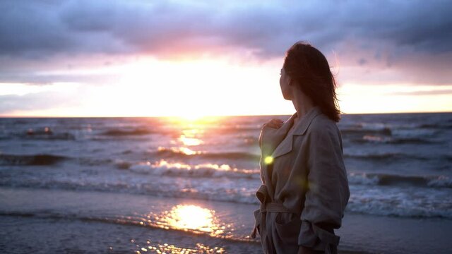 Young Woman Melancholically Looking into Sunset over the Sea.