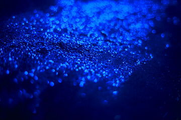 Blue glitter texture. Sequins scattered on a black background. Shimmering effect. Bokeh.
