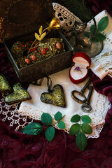 Retro style still life with hearts, ring, lace and golden rose on jewelry box on purple velvet...