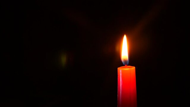 closeup of candle on black. Someone extinguishes the candle flame with your fingers 4K. Slow motion