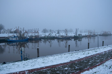 Fishing boats in the wintry harbor of Greetsiel