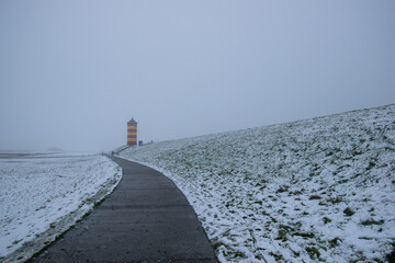 Otto lighthouse in Pilsum in the snow with fog in winter