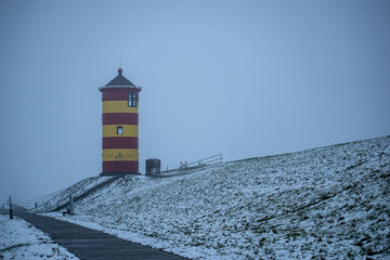 Otto lighthouse in Pilsum in the snow with fog in winter