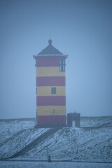 Otto lighthouse in Pilsum in the snow with fog in winter