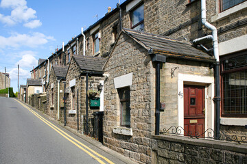 Mossley, England - A row of houses on a steep residential road in Mossley, a town and civil parish in Tameside, Greater Manchester, England.  Image has copy space.