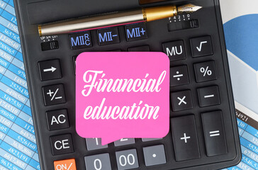 On the desktop are charts, reports, a calculator and a sheet for notes on which it is written - Financial education