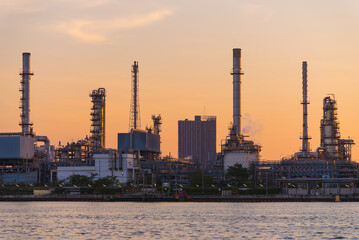 Fototapeta premium Close up oil and gas industrial, Refinery factory oil storage tank and pipeline steel at sunrise