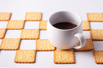 Obraz na płótnie Canvas Cup of coffee on a background of square cookies. On white background.