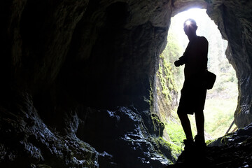 Entrance to Radesei cave, with the silhouette of a man against the sky