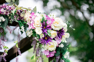 Purple, pink, yellow, white flowers hanging outside fresh with bokeh in the background ; beautiful wedding decoration