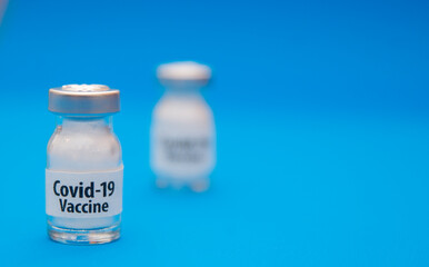 Coronavirus vaccine concept and syringe on blue background with copy space