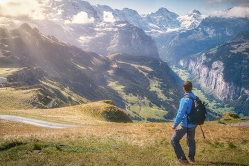 Backpacker enjoying the amazing views from Mannlichen mountain, Lauterbrunnen, Switzerland.