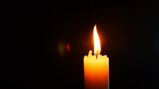 closeup of candle on black. Dying out the flame of a white candle. Smoke from the wick. 4 k. Slow-motion shooting.