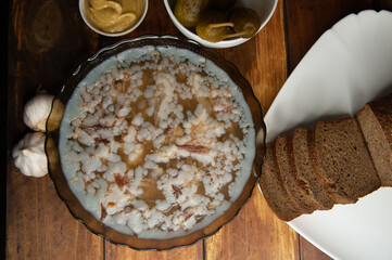 Jellied meat on a brown wooden background.Homemade jelly meat with mustard and horseradish on the table. Holodets