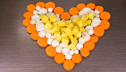 heart shaped vegetables on wooden background / valentines day