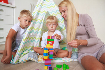 Mom and son build a tower together from constructor