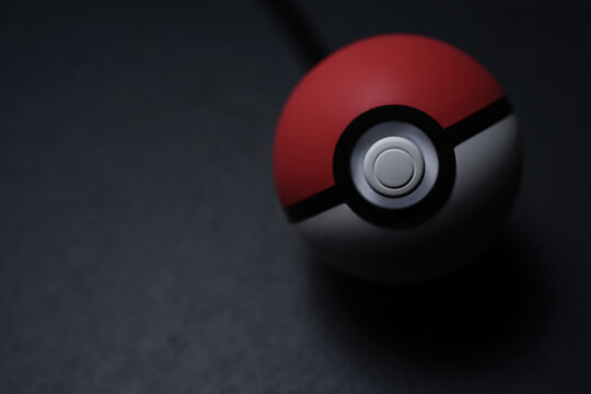 KUALA LUMPUR, MALAYSIA - JUNE 13TH, 2019 : A Poké Ball Plus on a black slate stone, you can bring your Pokémon adventure into the real world with an accessory that fits in the palm of your hand