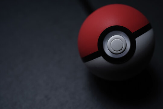 KUALA LUMPUR, MALAYSIA - JUNE 13TH, 2019 : A Poké Ball Plus on a black slate stone, you can bring your Pokémon adventure into the real world with an accessory that fits in the palm of your hand