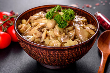 Fresh delicious spicy canned mushrooms with spices and herbs in ceramic dishes