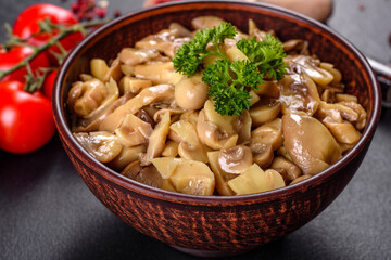 Fresh delicious spicy canned mushrooms with spices and herbs in ceramic dishes
